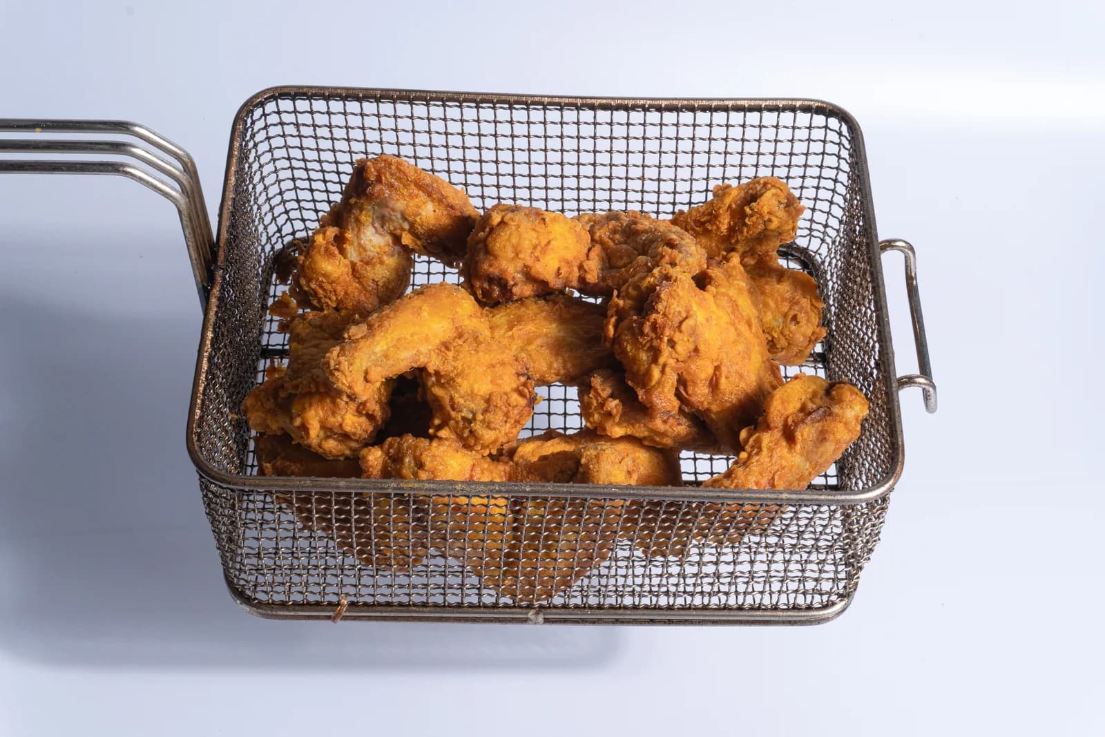 Poulet frit MEALZ photographié dans son panier de cuisson